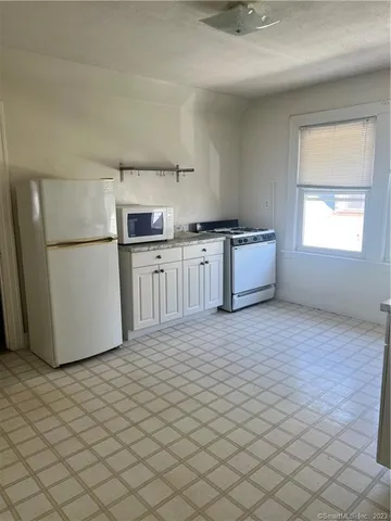 a kitchen with a refrigerator sink and cabinets