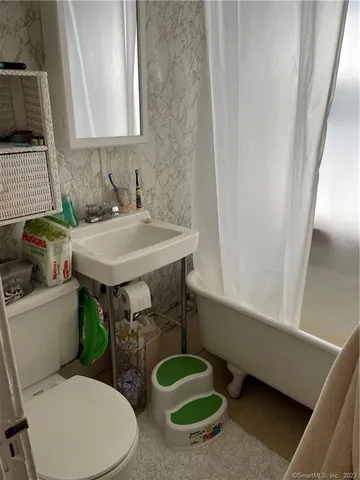 a bathroom with a sink a toilet and a mirror