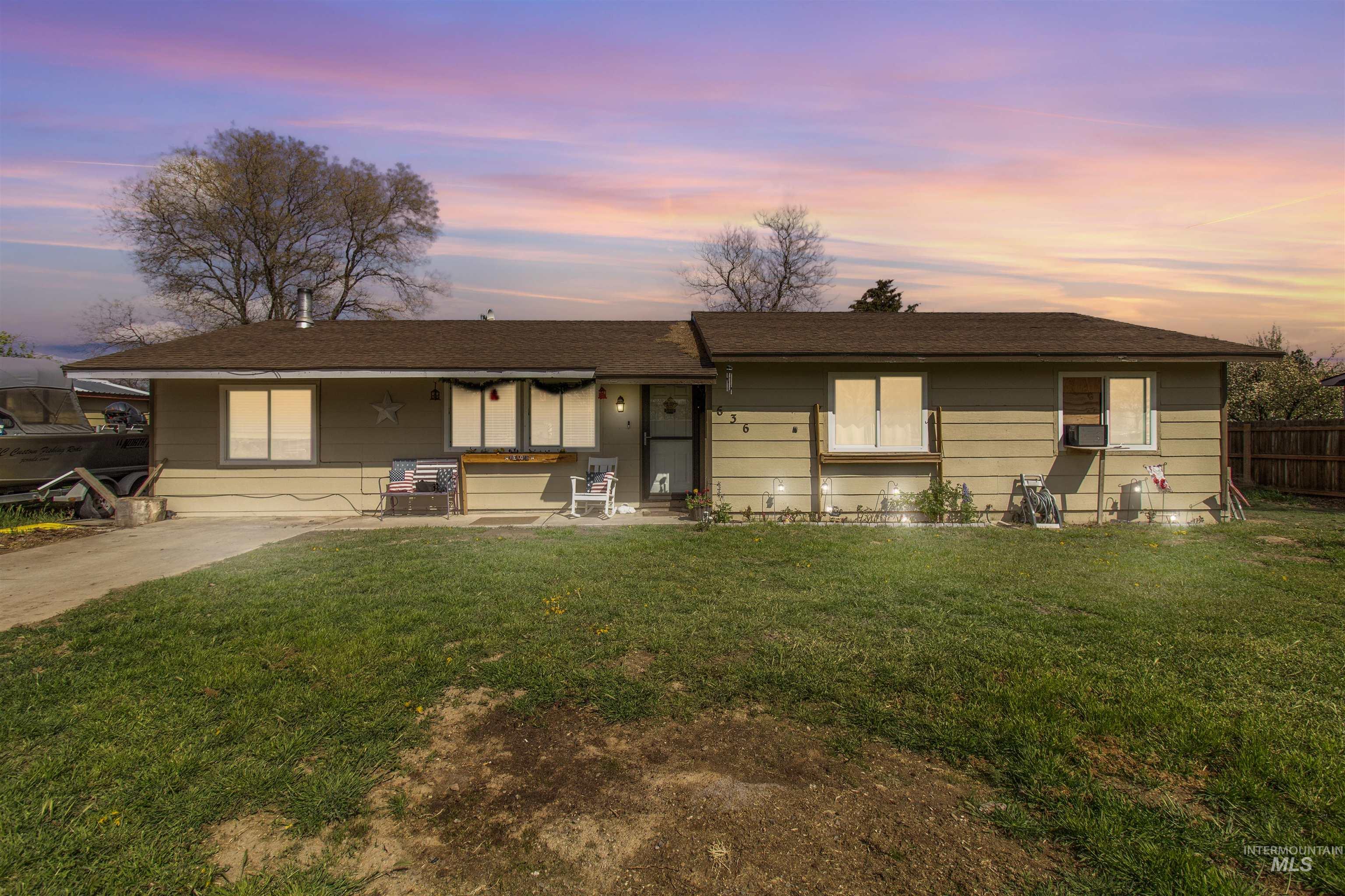 Single-story property featuring a front lawn and a partial fence