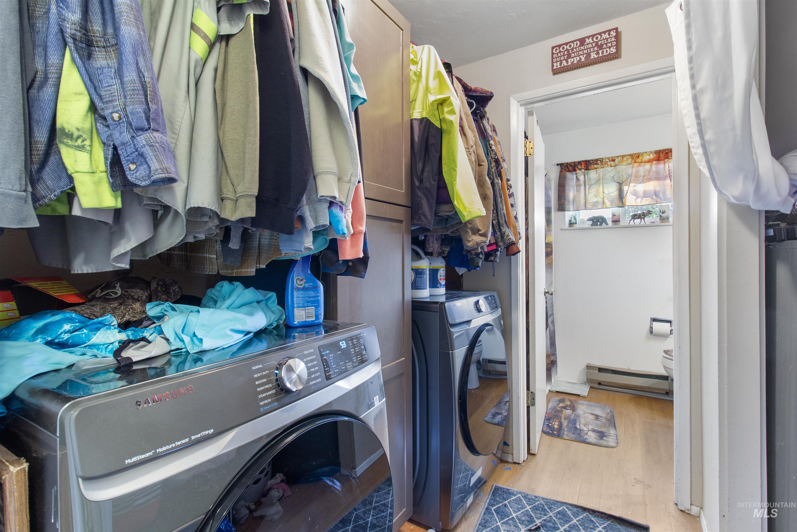 636 Main Street Hansen, ID 83334 - Photo 15 of 37 Laundry area featuring built-in cabinetry, wood-finish flooring, and a stacked washer and dryer