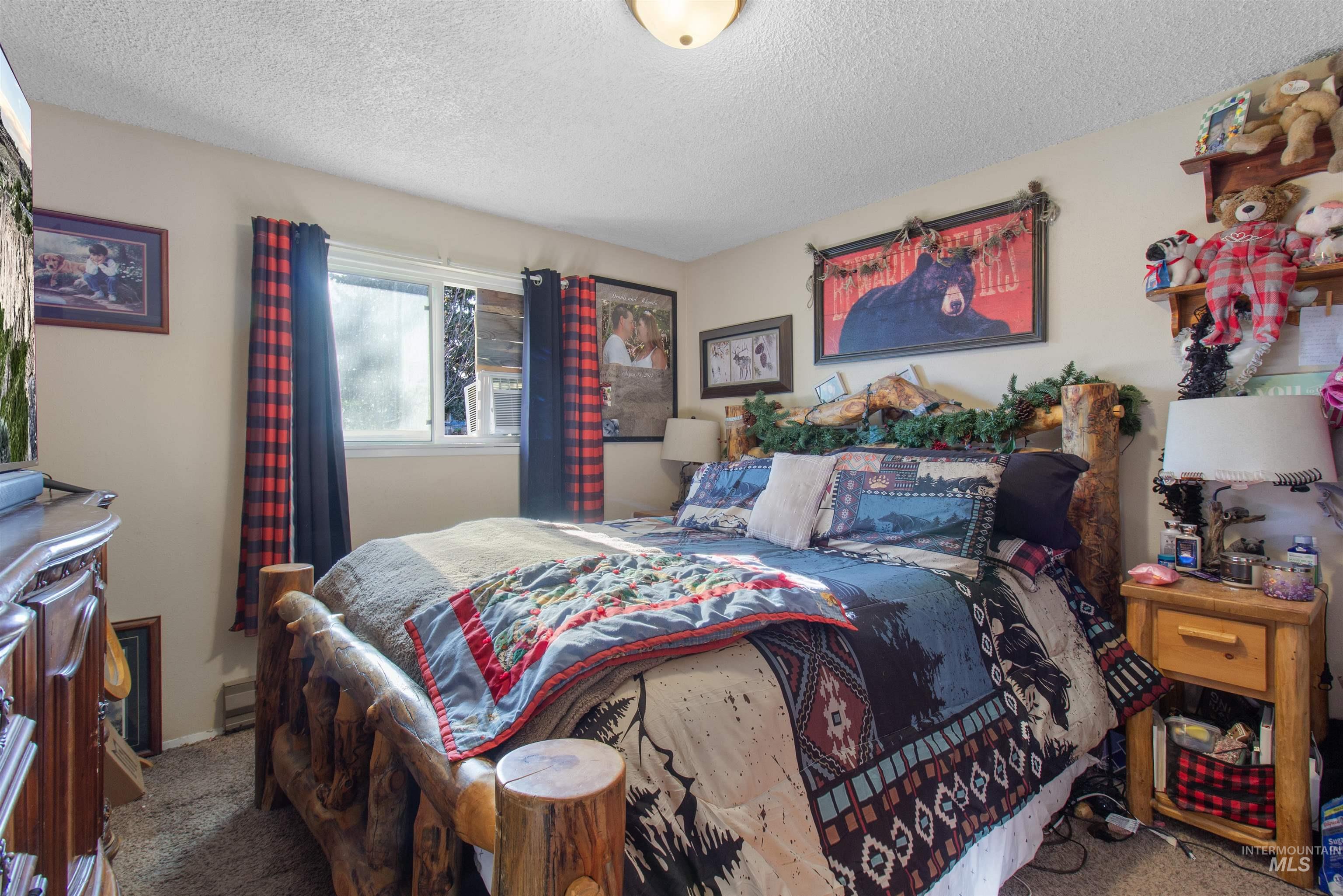636 Main Street Hansen, ID 83334 - Photo 16 of 37 Bedroom featuring a window with plaid curtains, light beige wall paint, and a textured ceiling