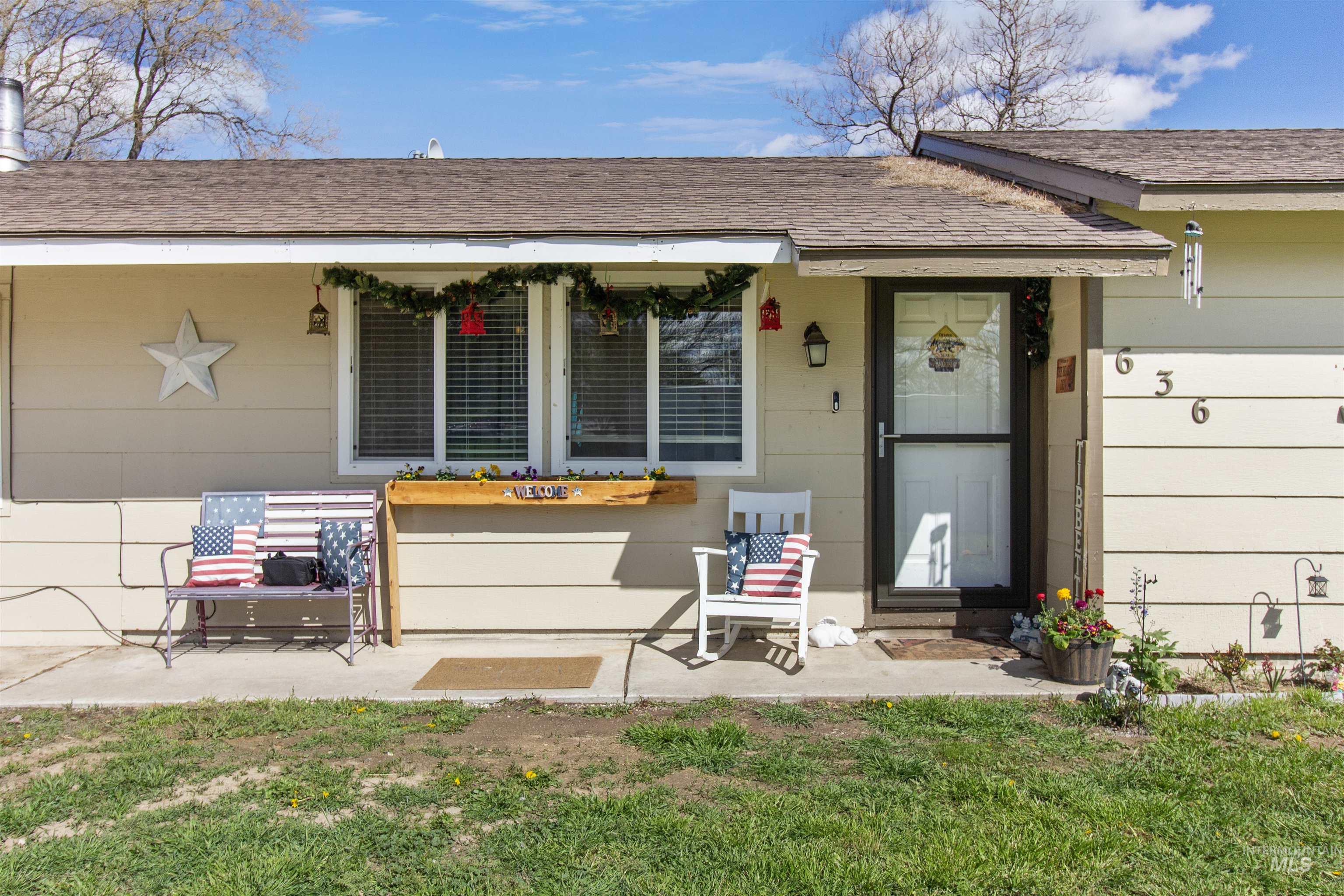 636 Main Street Hansen, ID 83334 - Photo 25 of 37 Inviting front porch featuring a white entry door with a storm door, an exterior wall light, and a window with blinds