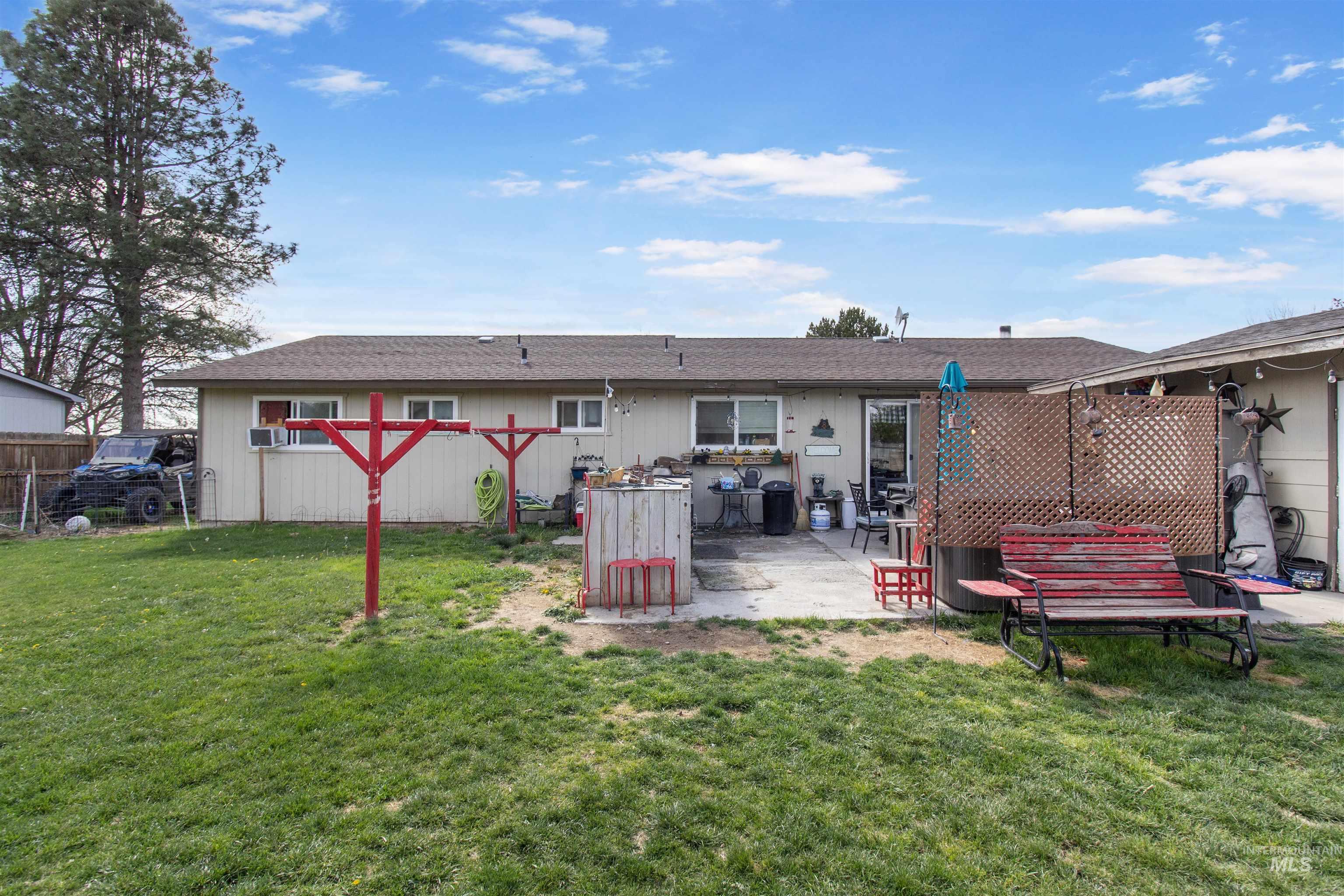 636 Main Street Hansen, ID 83334 - Photo 29 of 37 Expansive rear yard featuring a concrete patio, perimeter fencing, and a detached structure