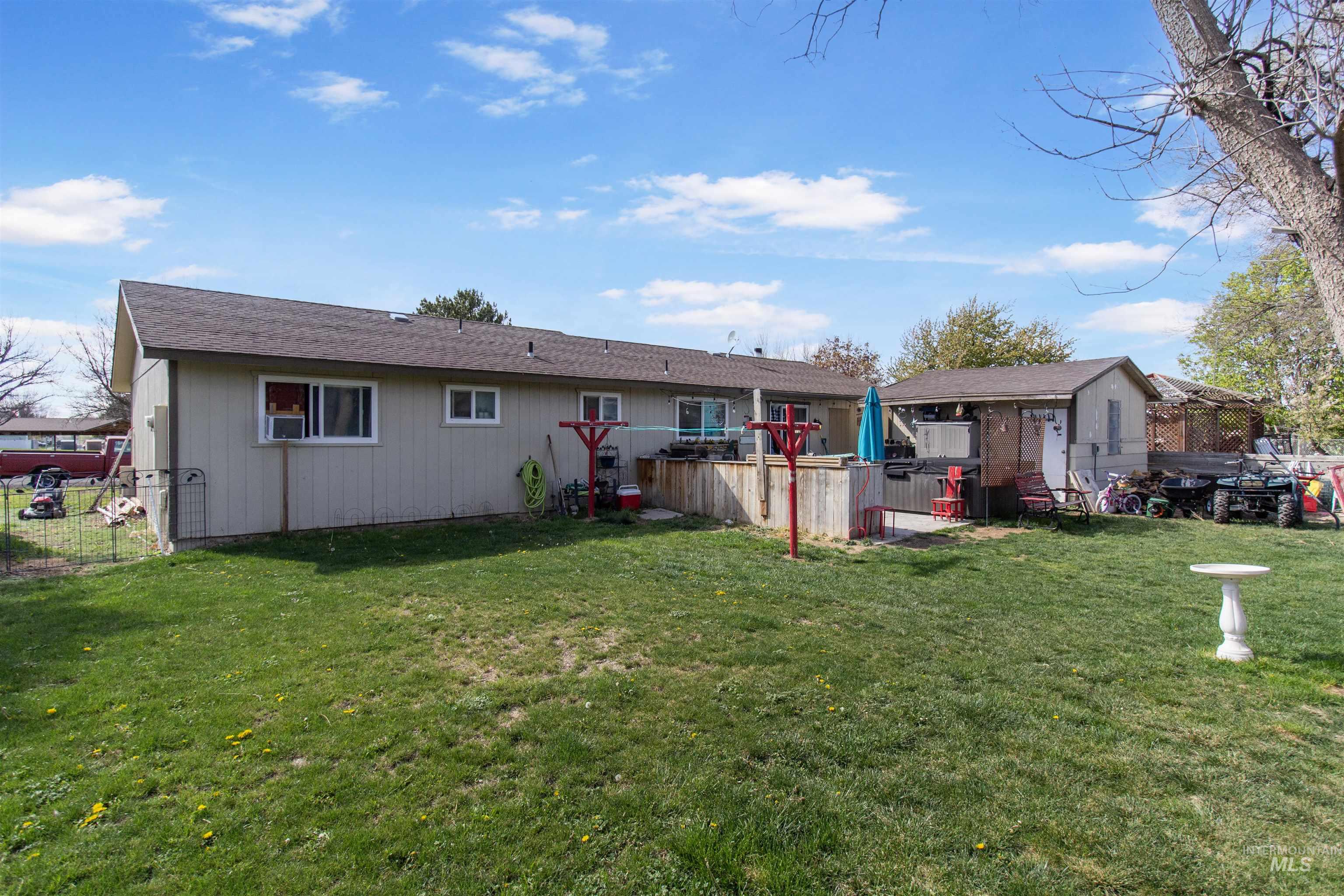 636 Main Street Hansen, ID 83334 - Photo 30 of 37 Expansive backyard featuring a manicured lawn, a raised wooden deck, and an outbuilding with additional storage