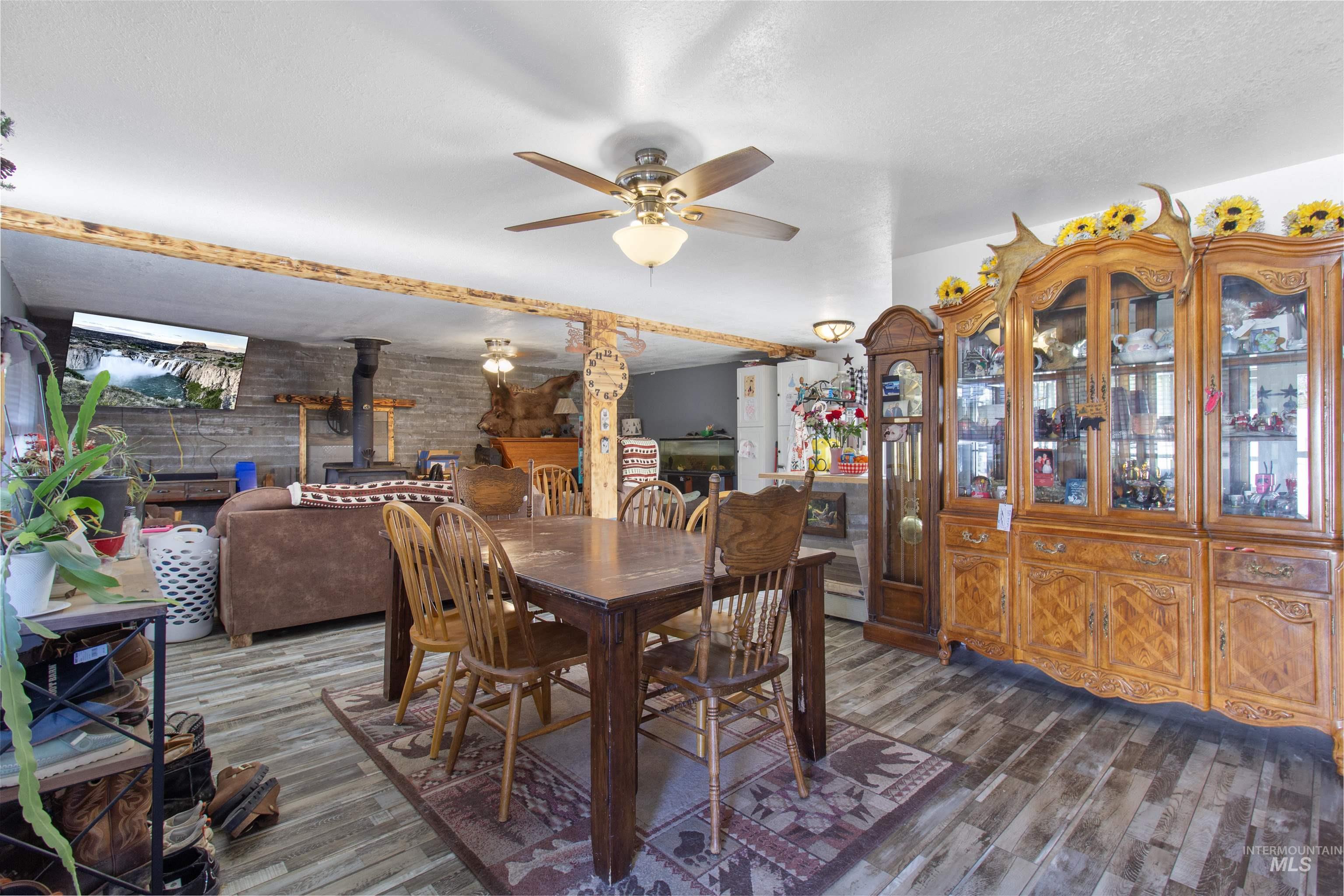 636 Main Street Hansen, ID 83334 - Photo 3 of 37 Open-concept living area featuring wood-finish flooring, a ceiling fan, and exposed wood beam accents