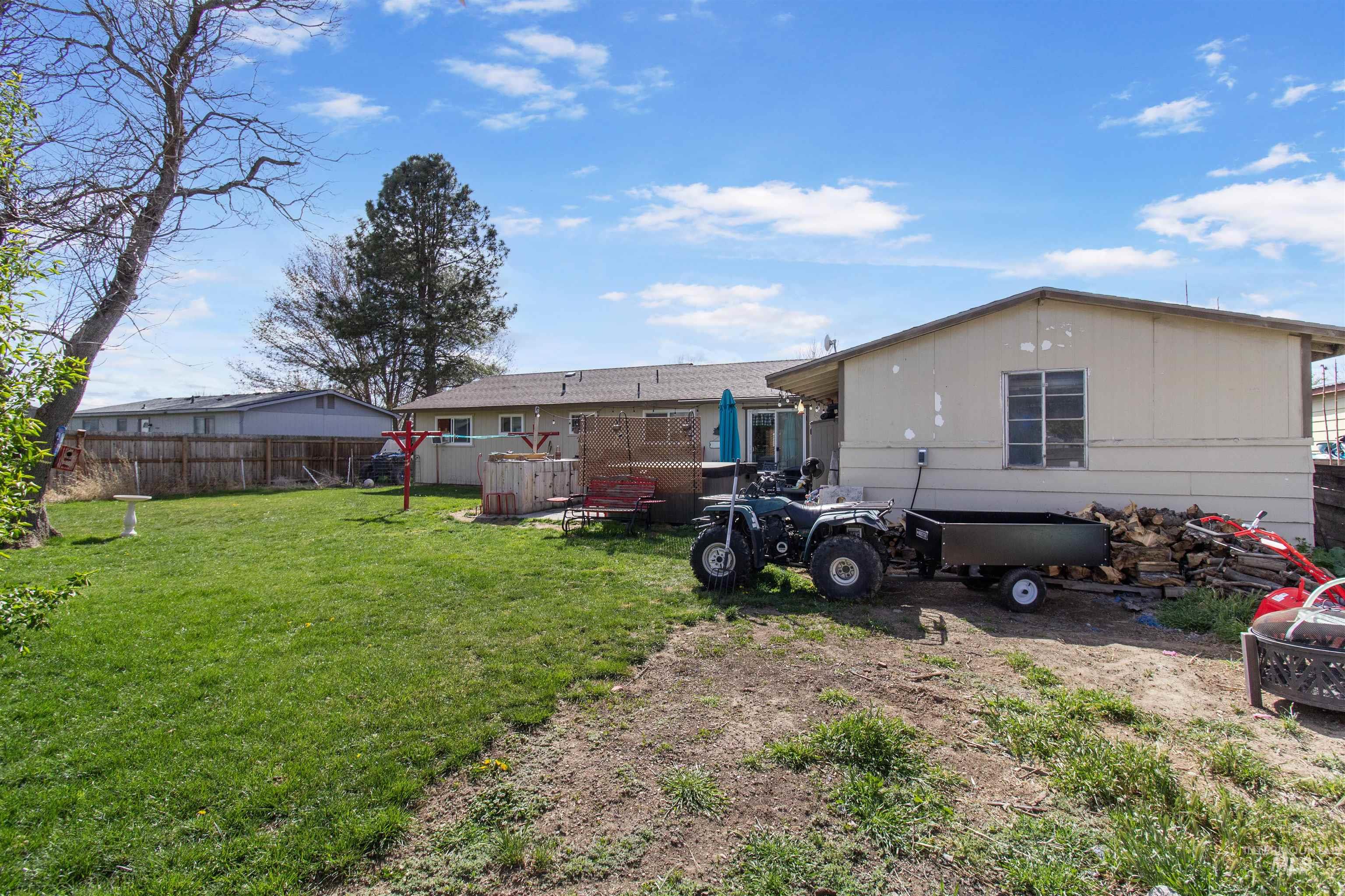 636 Main Street Hansen, ID 83334 - Photo 31 of 37 Expansive grassy yard with a privacy fence and mature trees
