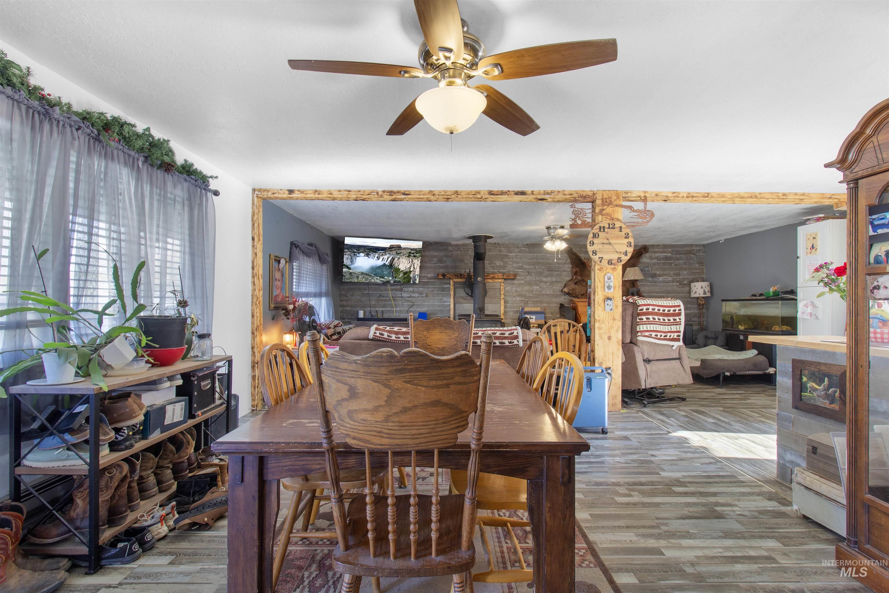 636 Main Street Hansen, ID 83334 - Photo 4 of 37 Open concept dining area featuring wood-finish flooring, a ceiling fan with integrated lighting, and a broad opening to the living space