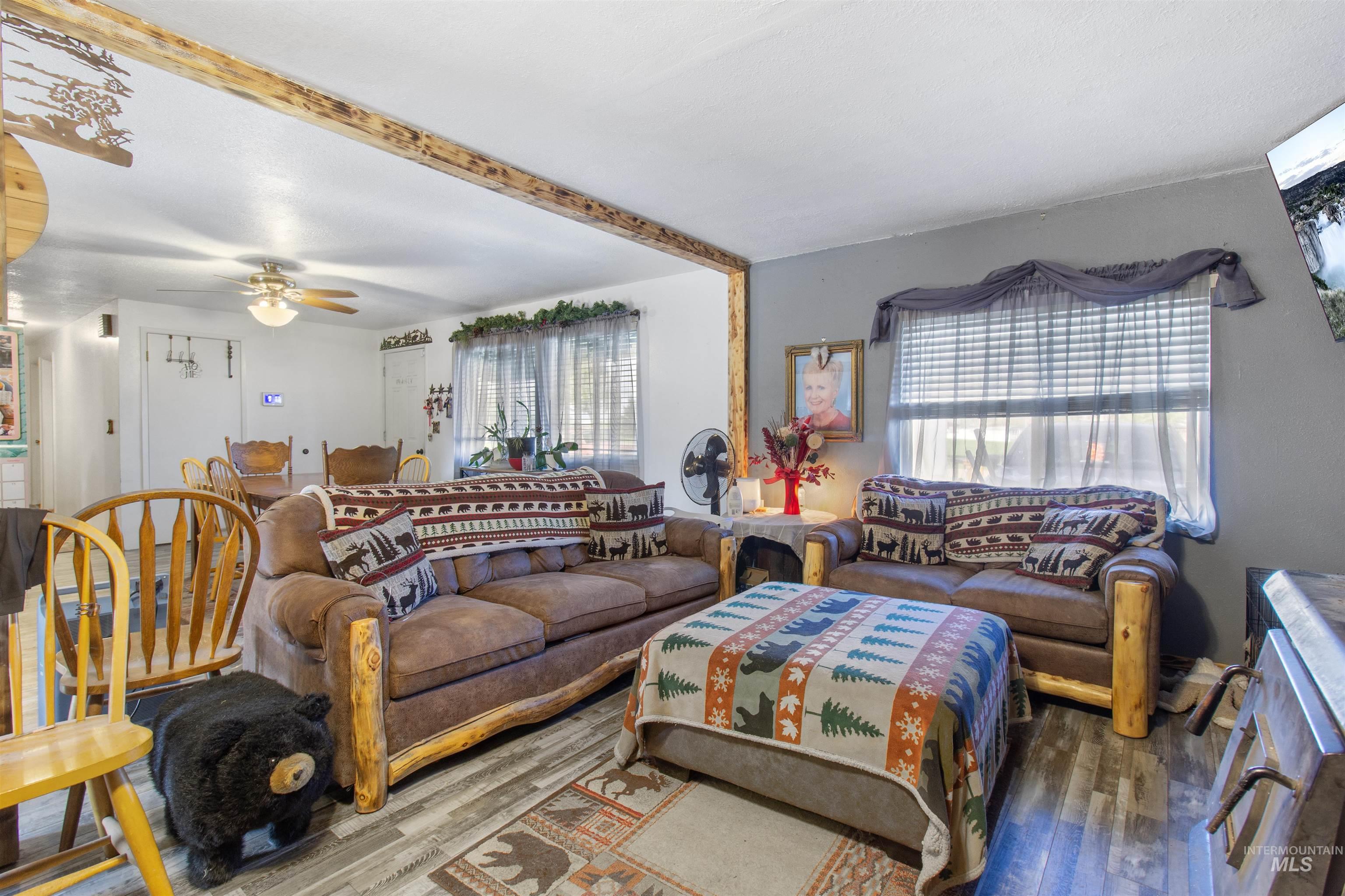 636 Main Street Hansen, ID 83334 - Photo 6 of 37 Living area featuring wood-finish flooring, a decorative wood beam, and a ceiling fan