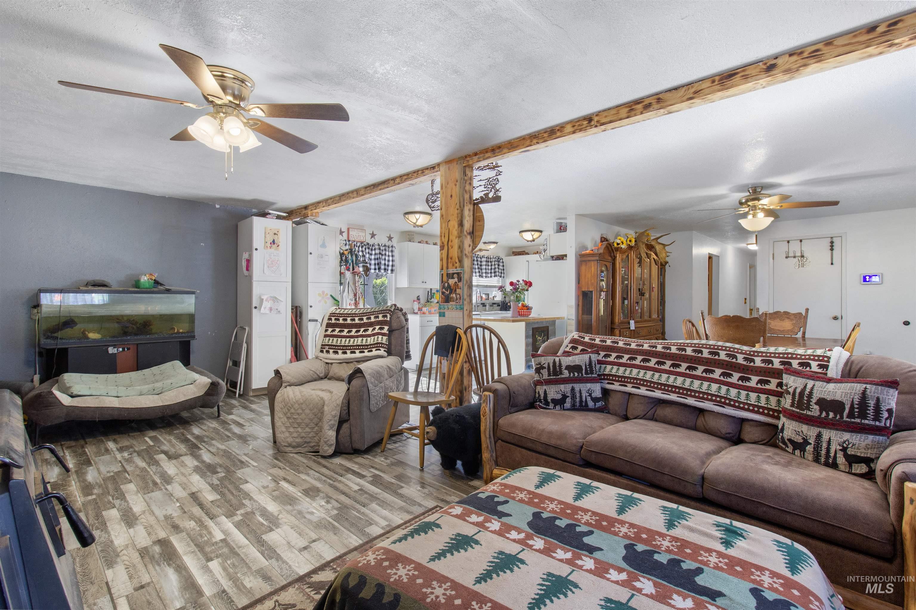 636 Main Street Hansen, ID 83334 - Photo 9 of 37 Spacious interior with wood-finish flooring, exposed wood beams, and ceiling fans