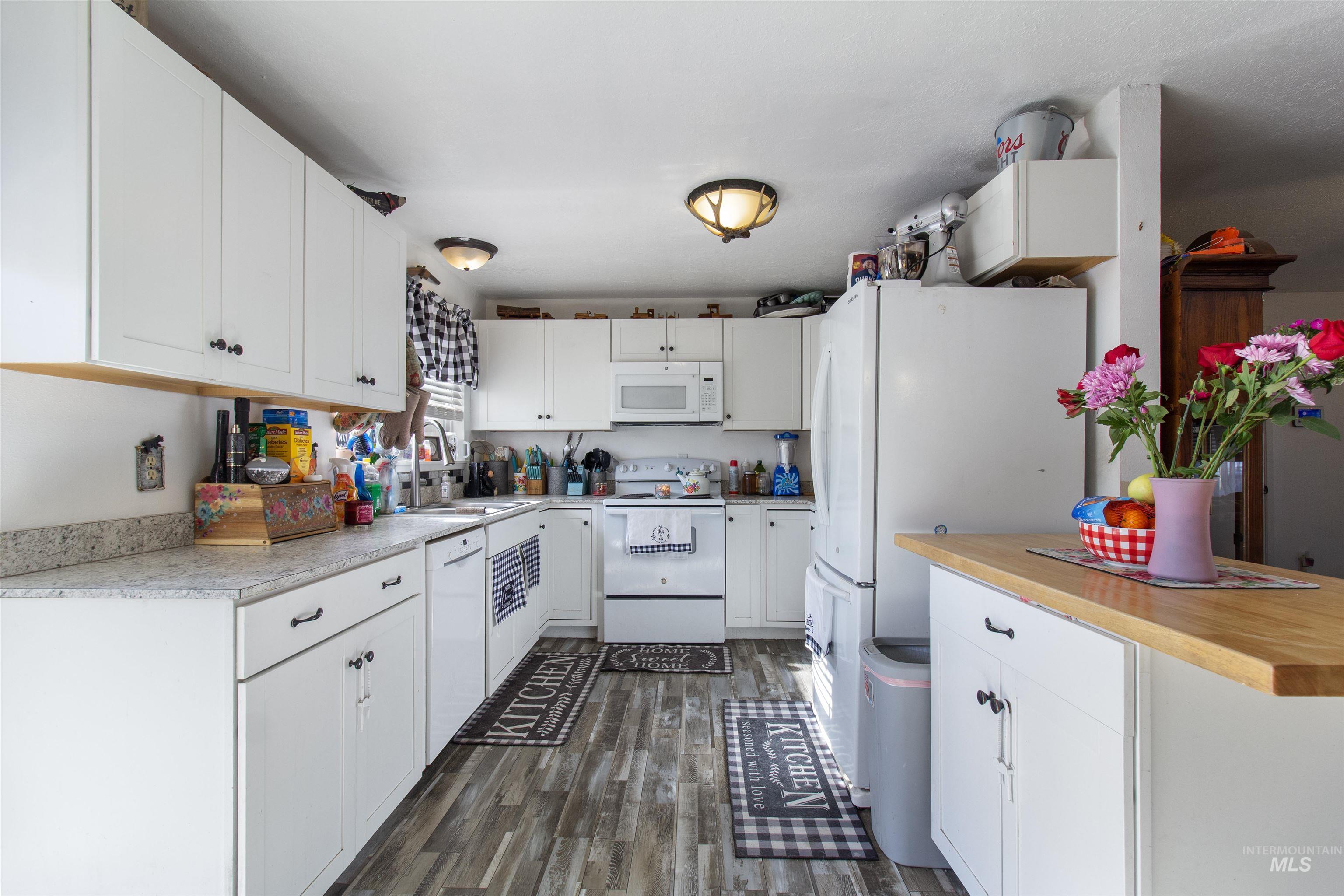 636 Main Street Hansen, ID 83334 - Photo 10 of 37 Bright kitchen featuring white cabinetry, light-toned countertops, wood-finish flooring, and a central island with a butcher block top