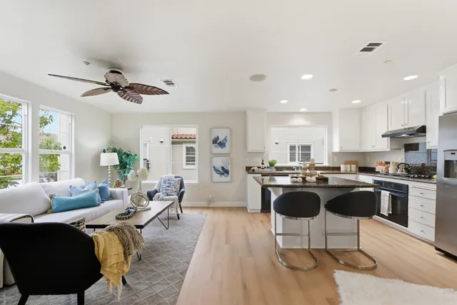 a living room with stainless steel appliances kitchen island granite countertop furniture a rug and a view of kitchen
