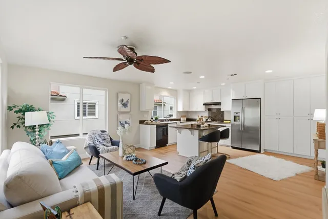 a living room with stainless steel appliances kitchen island granite countertop furniture and a kitchen view