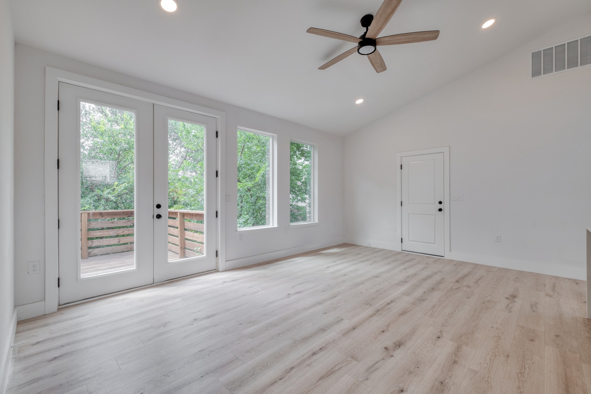 5211 Rob-Scott Street Austin, TX 78721 - Photo 6 of 24 A spacious room offers ample natural light and direct access to an outdoor deck, perfect for indoor-outdoor living.