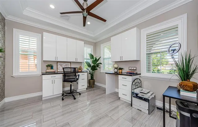 a view of a patio with table and chairs potted plants and floor to ceiling window