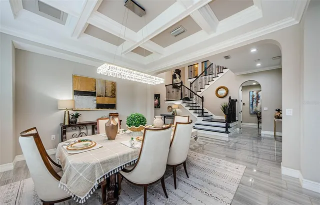 a view of a dining room with furniture a rug and wooden floor