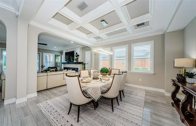 a kitchen with stainless steel appliances granite countertop a stove a refrigerator a kitchen island a dining table and chairs with wooden floor