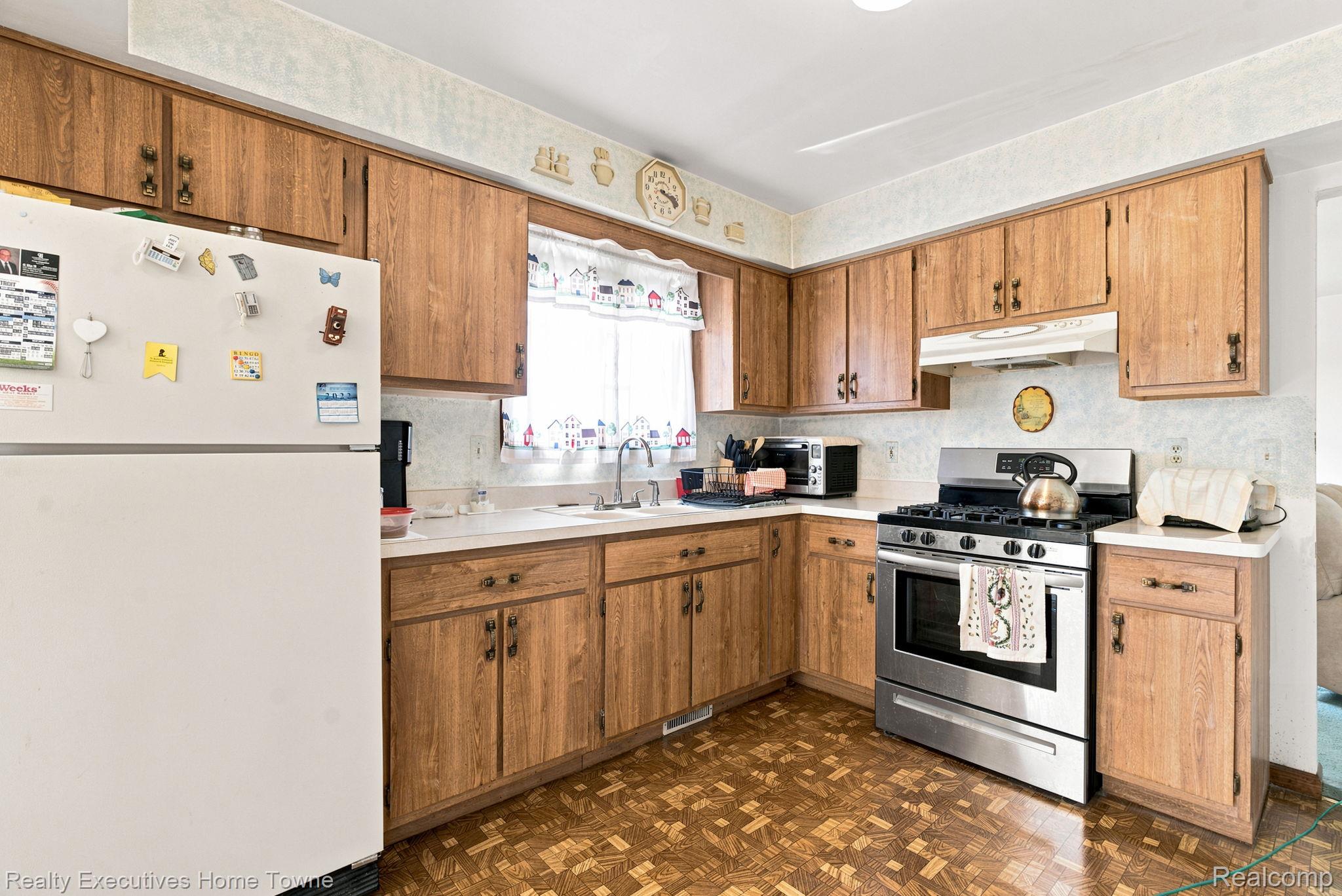 959 Braidwood Road Memphis, MI 48041 - Photo 22 of 58 Kitchen featuring wood-finish cabinetry, white countertops, a stainless steel range with overhead ventilation, and patterned flooring