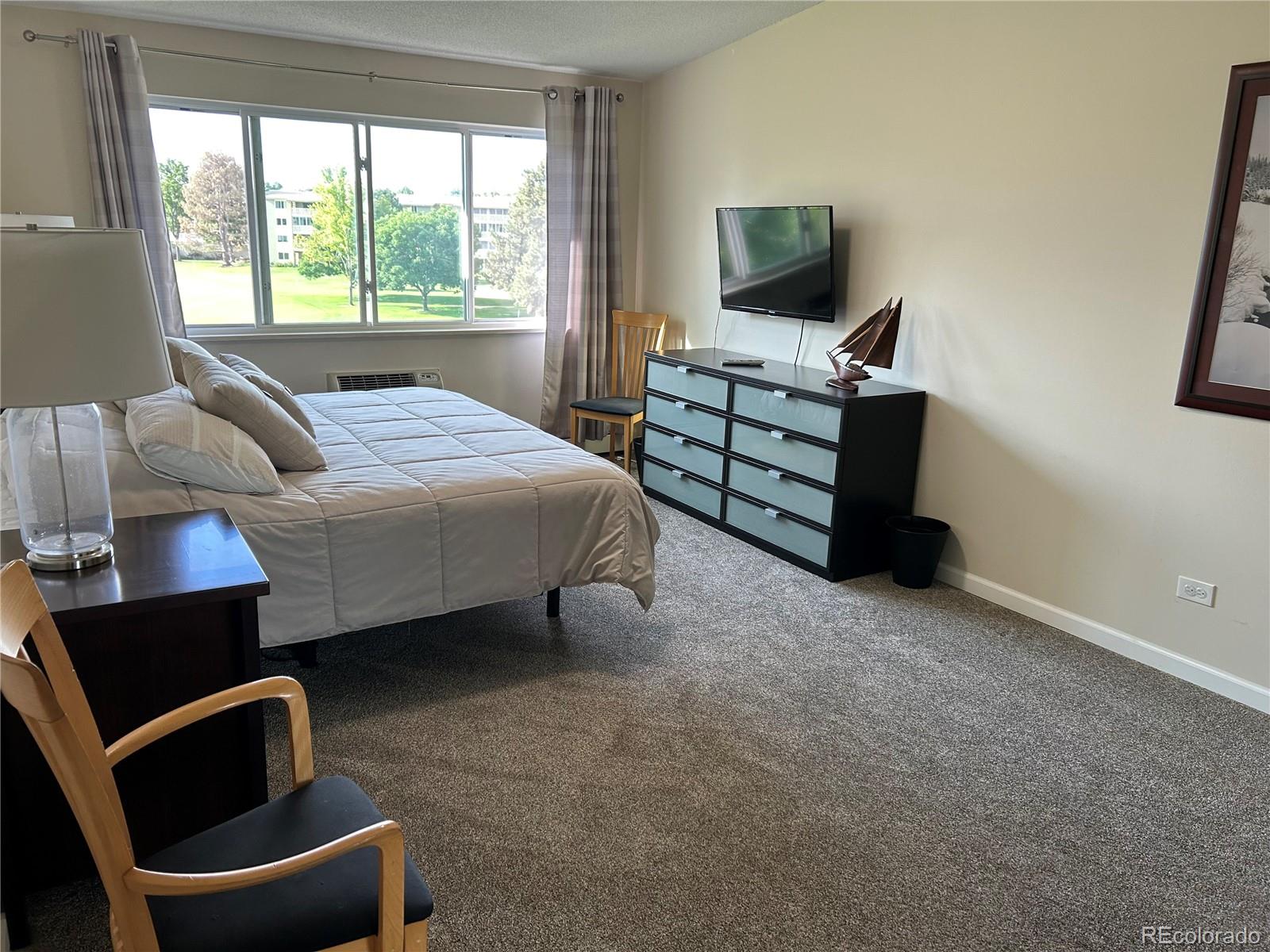 9180 Center Avenue, Unit 4D Denver, CO 80247 - Photo 13 of 19 a bedroom with a bed and a television