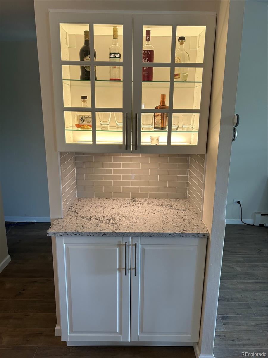 9180 Center Avenue, Unit 4D Denver, CO 80247 - Photo 5 of 19 a kitchen with granite countertop wooden cabinets and a floor to ceiling window