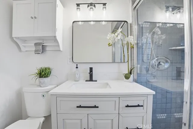 a bathroom with a sink a toilet and shower