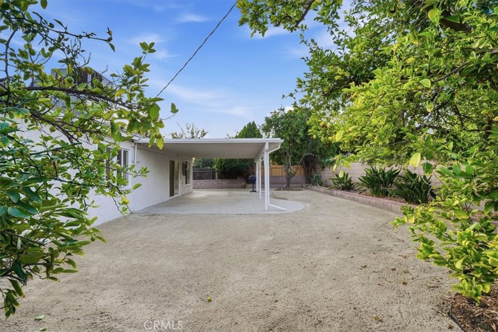 17751 Blythe Street Reseda, CA 91335 - Photo 19 of 23 a view of a house with potted plants and large trees