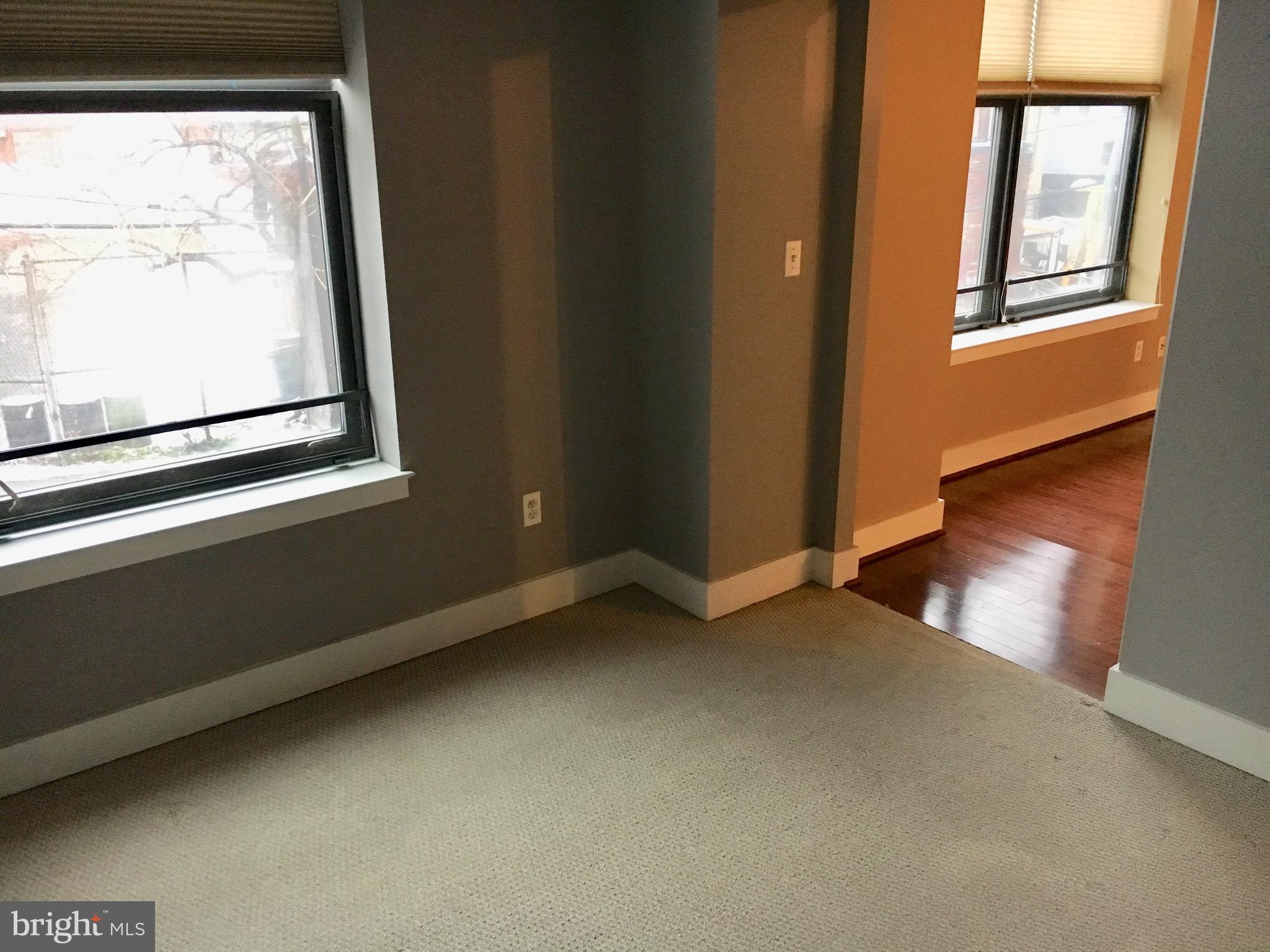 2301 Champlain Street Northwest, Unit 213 Washington, DC 20009 - Photo 16 of 40 a view of an empty room with wooden floor and a window