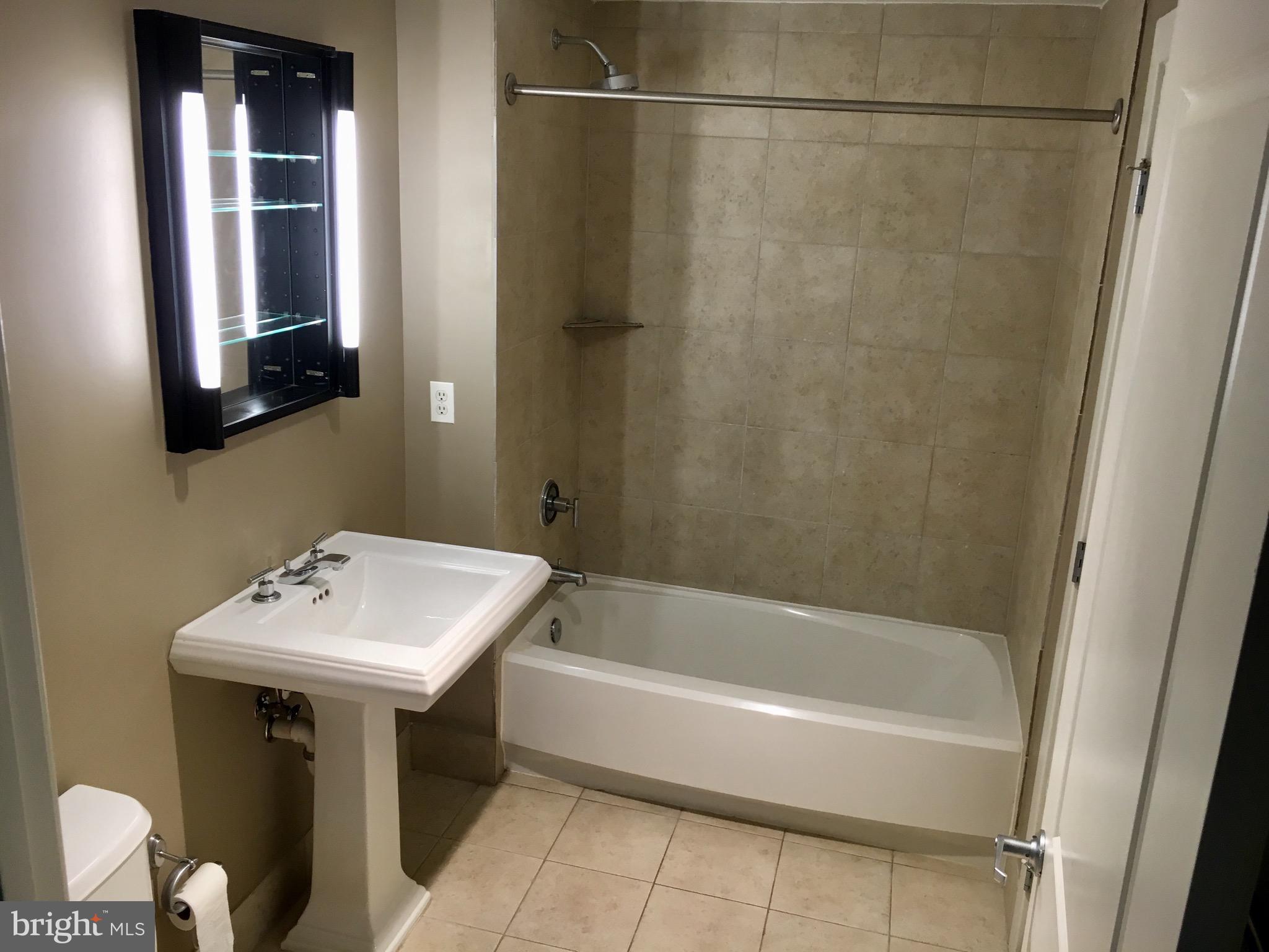 2301 Champlain Street Northwest, Unit 213 Washington, DC 20009 - Photo 27 of 40 a bathroom with a sink a mirror and a bathtub
