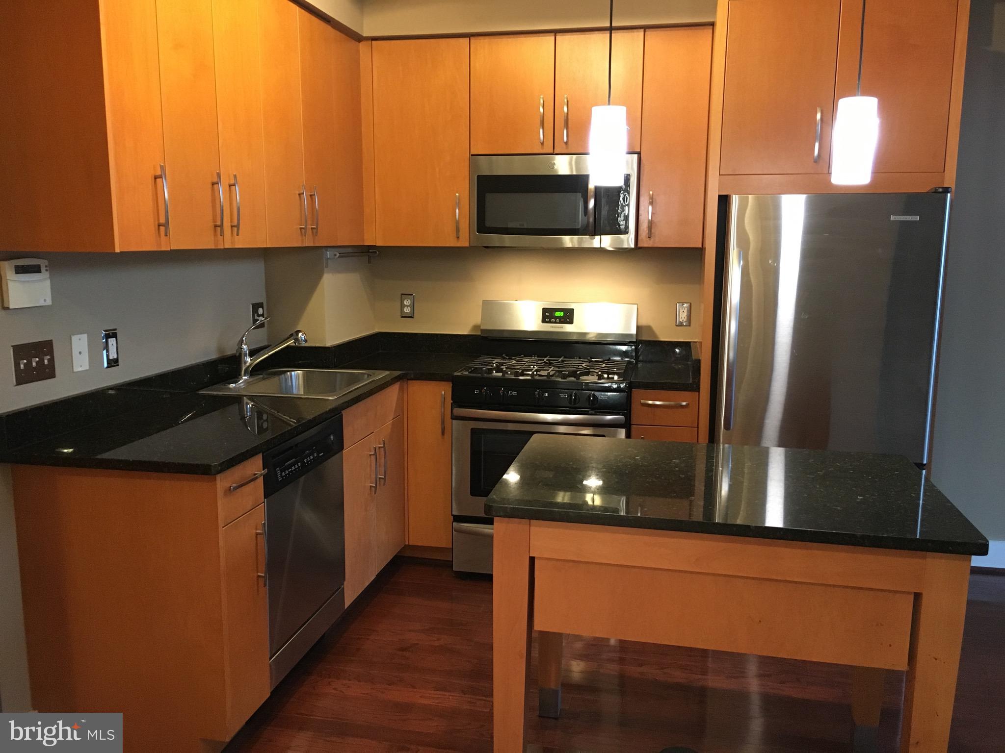 2301 Champlain Street Northwest, Unit 213 Washington, DC 20009 - Photo 4 of 40 a kitchen with stainless steel appliances granite countertop a stove a refrigerator and a microwave