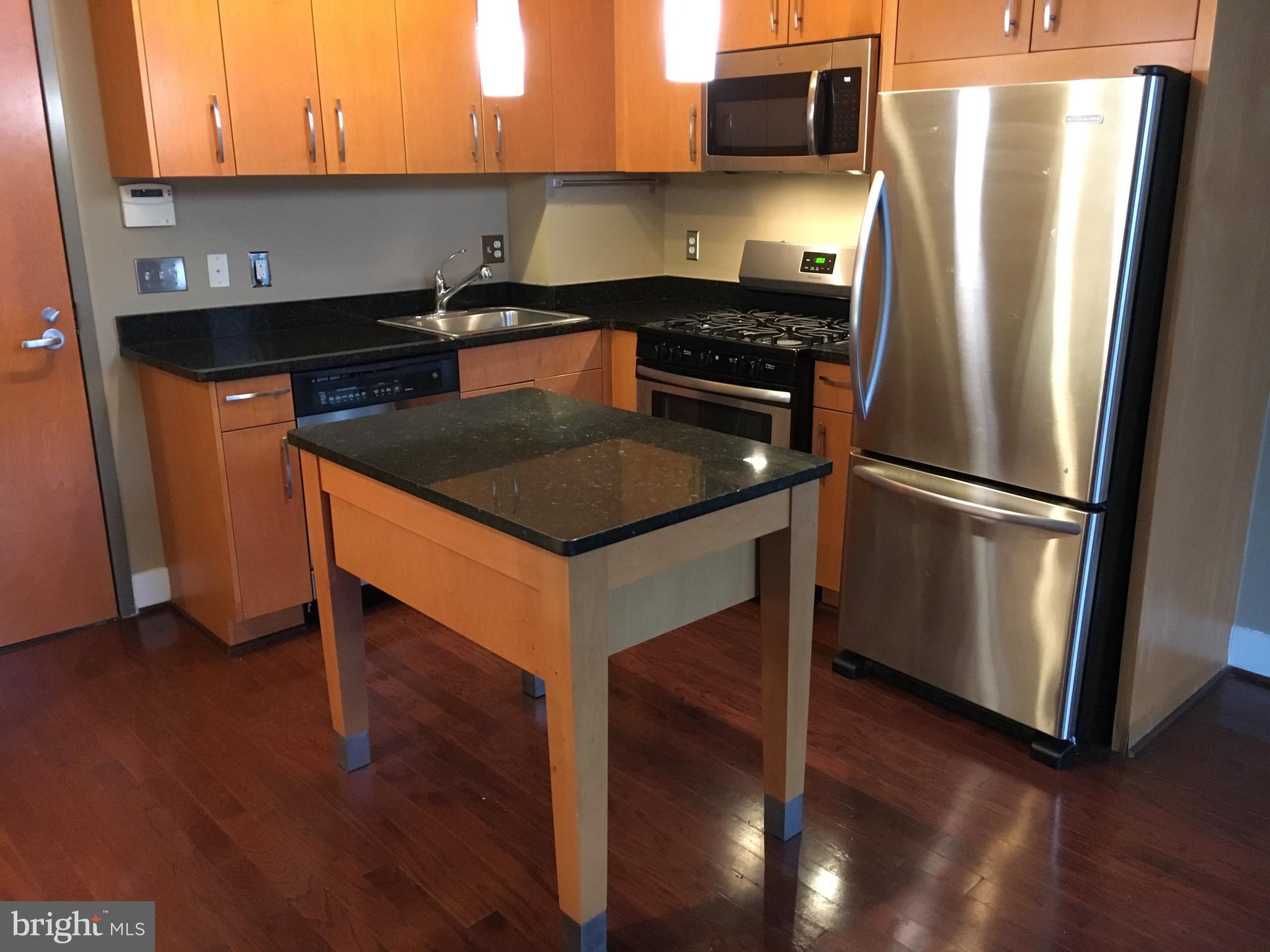 2301 Champlain Street Northwest, Unit 213 Washington, DC 20009 - Photo 5 of 40 a kitchen with granite countertop a refrigerator stove and sink