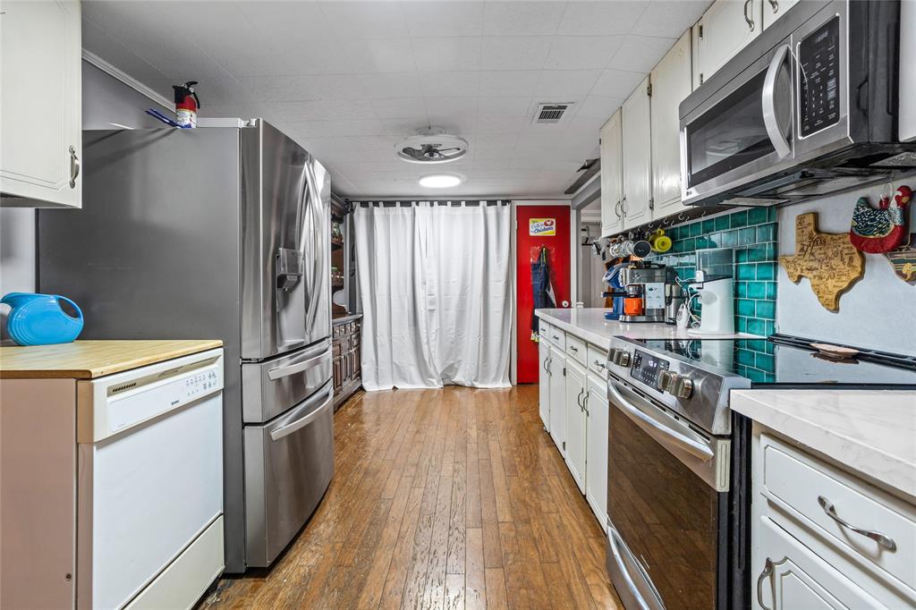 1641 Ben Davis Road Garland, TX 75040 - Photo 11 of 38 a kitchen with stainless steel appliances granite countertop a refrigerator a stove a sink and dishwasher with wooden floor