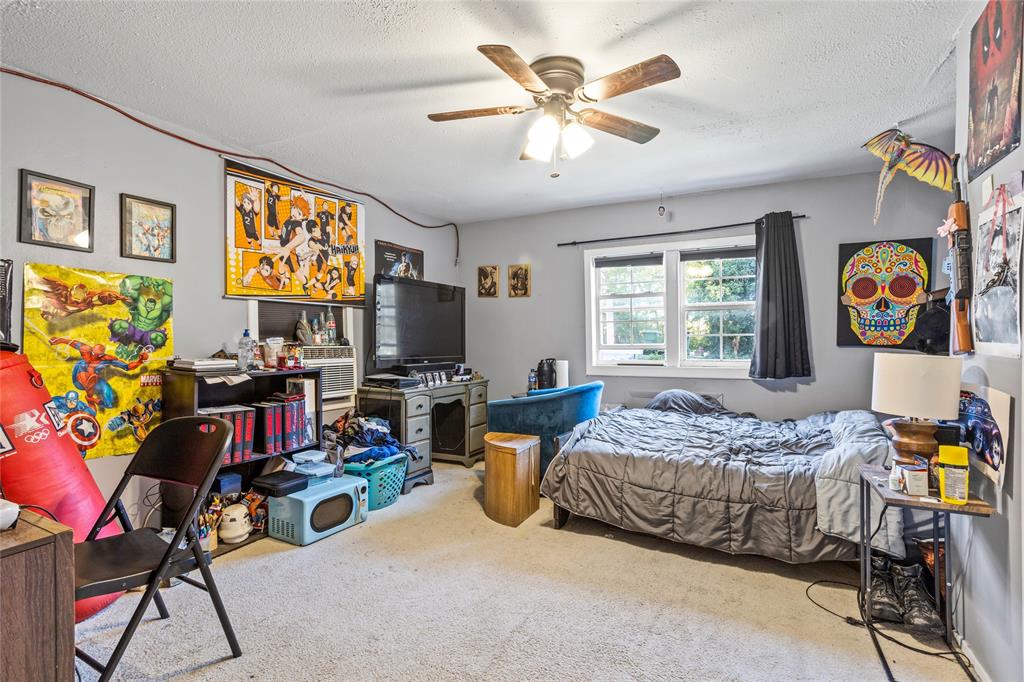 1641 Ben Davis Road Garland, TX 75040 - Photo 16 of 38 a bedroom with a bed a bookshelf and a bookshelf