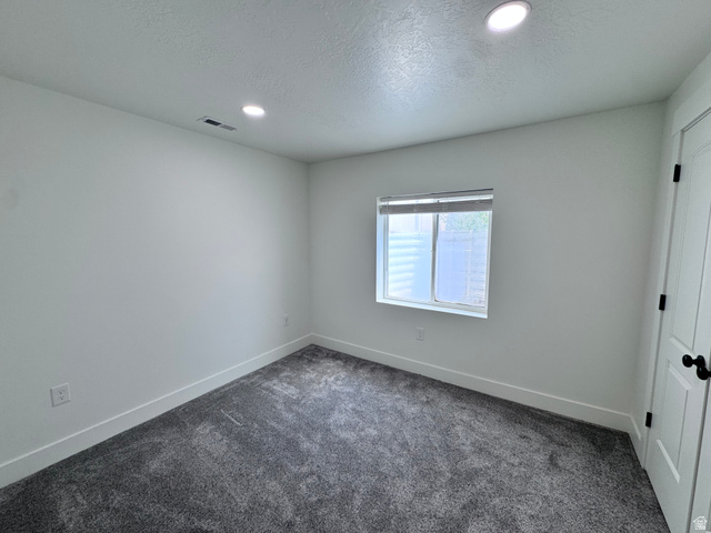 4729 Middleboro Road Herriman, UT 84096 - Photo 19 of 19 White-painted room featuring recessed lighting, a window with blinds, and dark grey carpeting