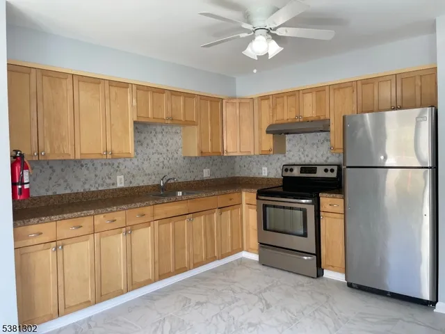 a kitchen with stainless steel appliances granite countertop a refrigerator sink and cabinets
