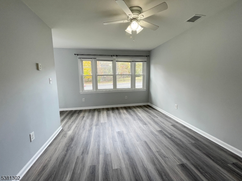 31 Lakeside Boulevard, Unit A Hopatcong, NJ 07843 - Photo 11 of 24 wooden floor in an empty room with a window