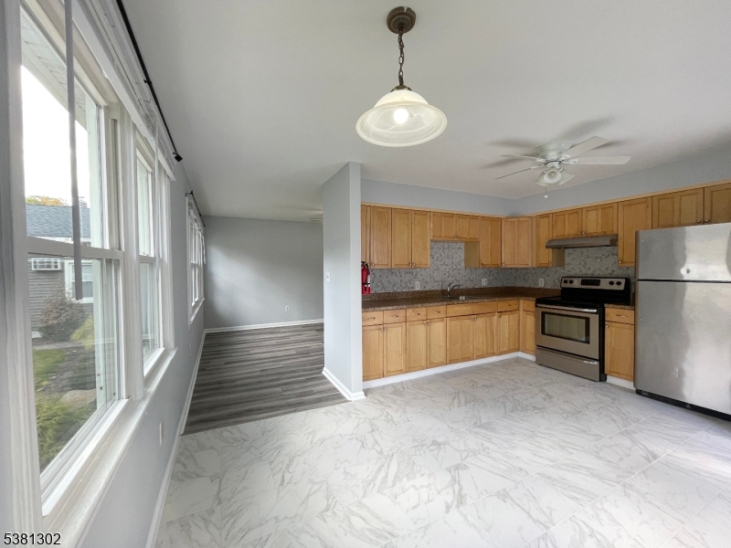 31 Lakeside Boulevard, Unit A Hopatcong, NJ 07843 - Photo 4 of 24 a kitchen with stainless steel appliances kitchen island granite countertop a refrigerator and a sink