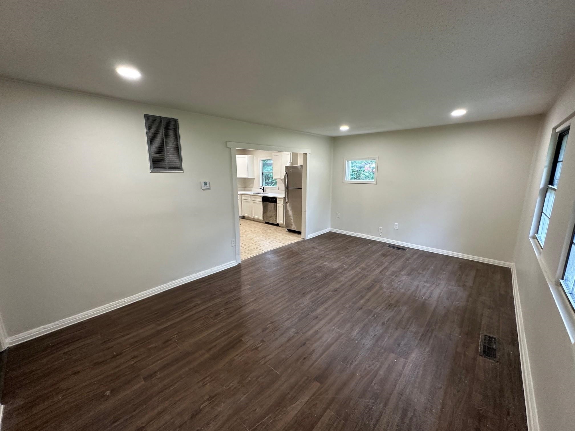 476 Mineral Road Memphis, TN 38120 - Photo 2 of 4 an empty room with wooden floor and windows