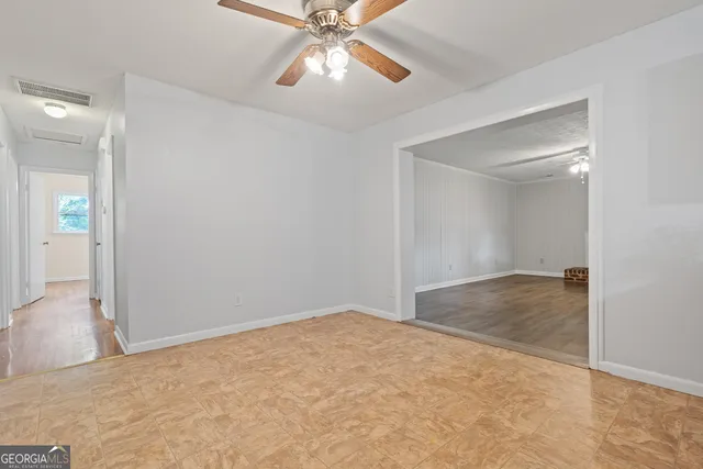 an empty room with fan and entrance