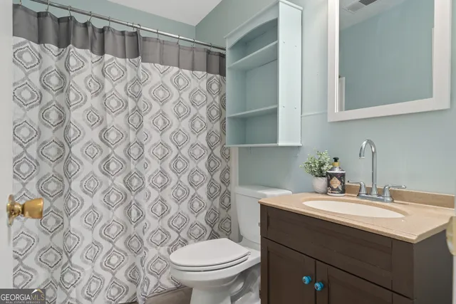 an empty room with wooden floor chandelier fan and windows
