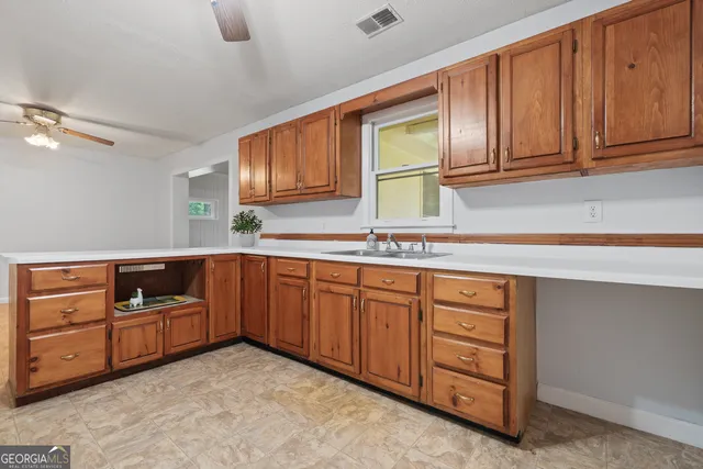 a kitchen with stainless steel appliances granite countertop a sink and cabinets with wooden floor