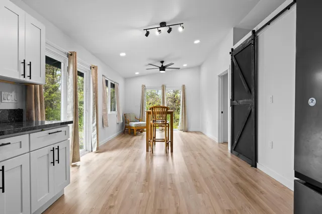 a view of a livingroom with furniture hardwood floor and a kitchen