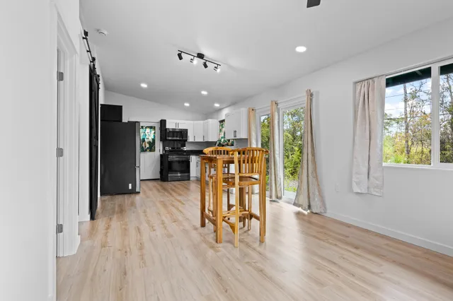 a view of a kitchen with furniture and wooden floor