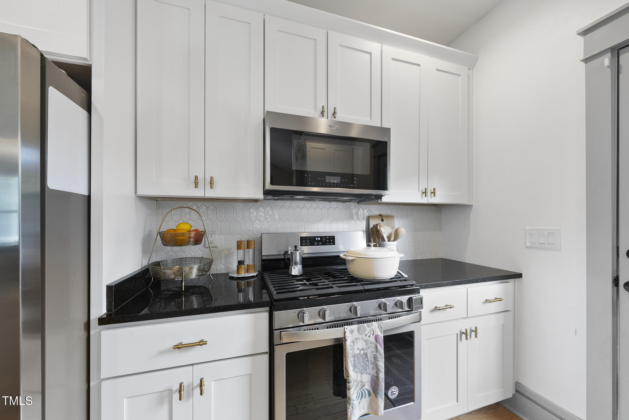 1010 South Person Street Raleigh, NC 27601 - Photo 10 of 41 a kitchen with stainless steel appliances granite countertop a stove a microwave and cabinets