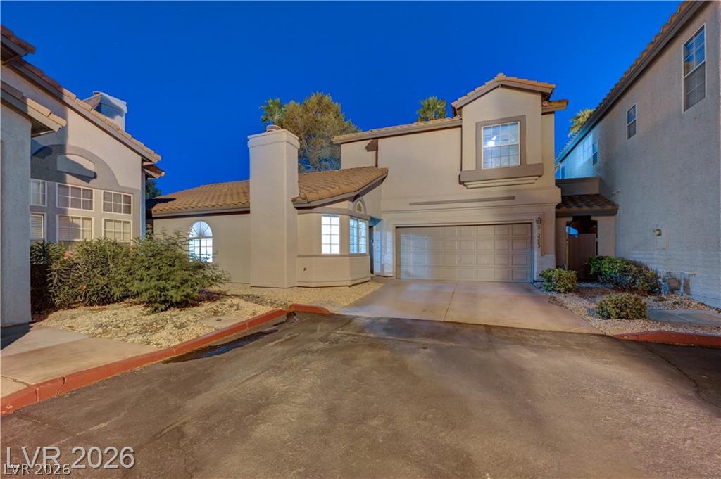 Spanish tile roofing and a two-car garage define this classic multi-level stucco exterior.
