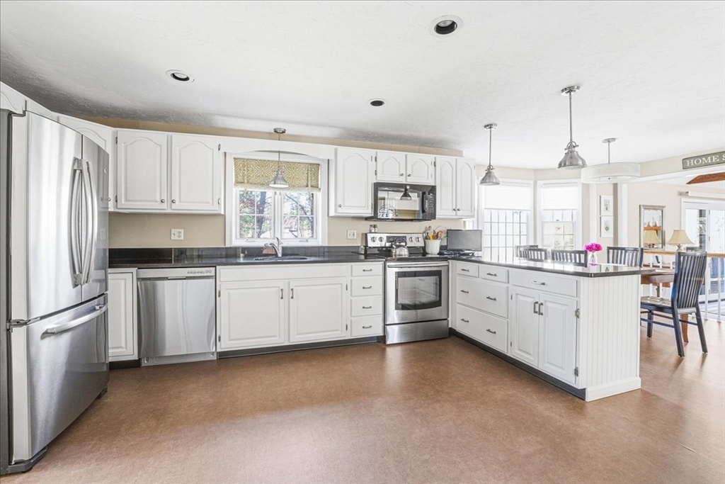 33 1st Parish Lane Hanover, MA 02339 - Photo 4 of 35 a kitchen with kitchen island granite countertop white cabinets white stainless steel appliances with a sink and dishwasher