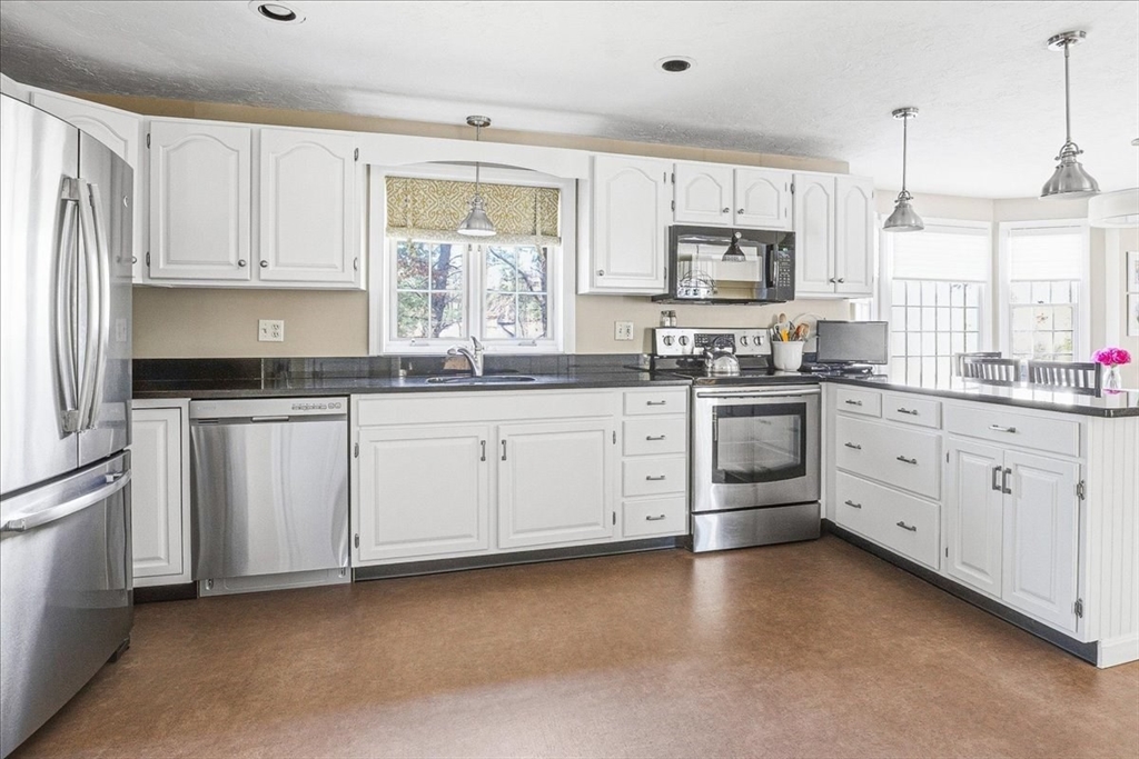 33 1st Parish Lane Hanover, MA 02339 - Photo 8 of 35 a kitchen with white cabinets sink and stainless steel appliances