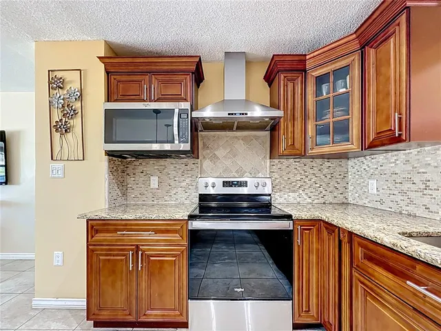 a kitchen with stainless steel appliances granite countertop a stove microwave and cabinets