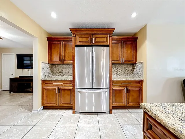 a kitchen with stainless steel appliances granite countertop a refrigerator and a stove top oven