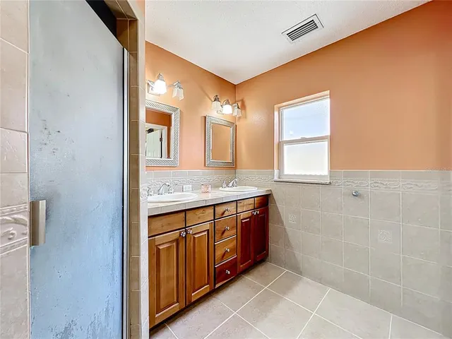 a spacious bathroom with a granite countertop sink a mirror and a bathtub
