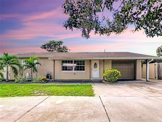a front view of a house with a garden and a tree