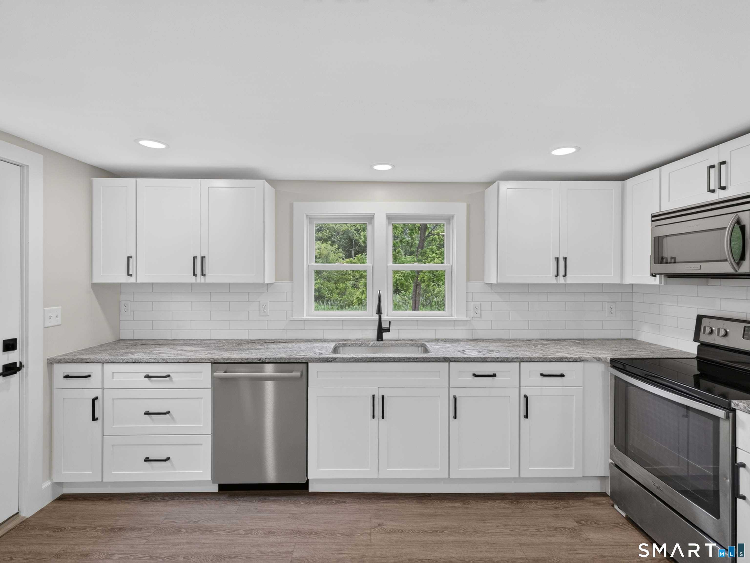 1039 N Road Groton, CT 06340 - Photo 9 of 26 a kitchen with granite countertop white cabinets and a sink